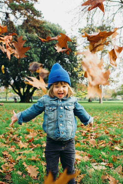 autumn-family-photoshoot-park-brighton-hove-ssusex-toddler-throwing-autumn-leaves-in-air.jpg