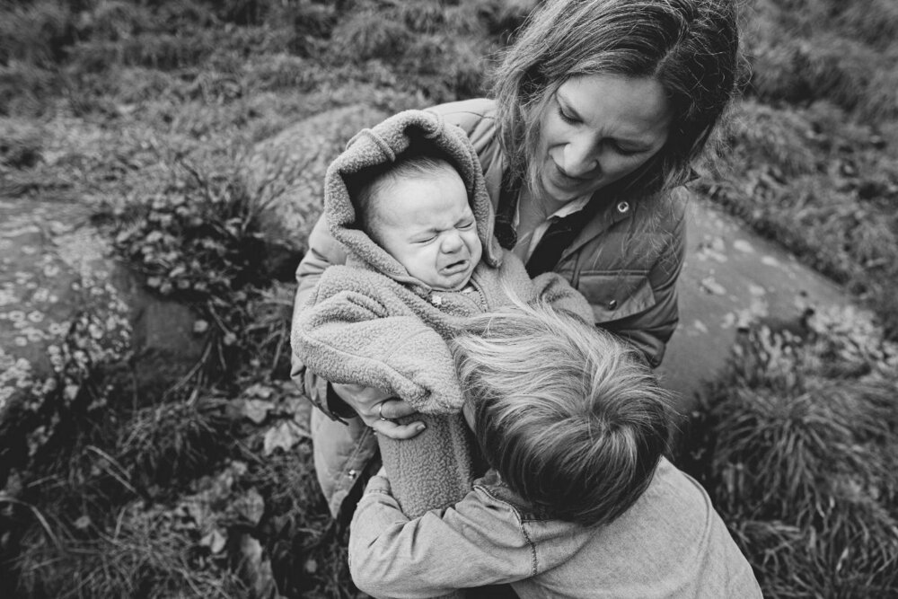 boy-hugging-baby-brother-documentary-style-family-photography-outdoors-stoke-newington-london.jpg